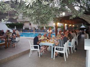a group of people sitting at tables at a restaurant at Lindos Athena in Lindos