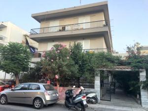 a motorcycle and a car parked in front of a building at Iridas house in Kos Town