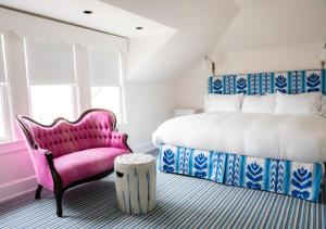 a bedroom with a pink chair and a bed at The Star Inn in Cape May