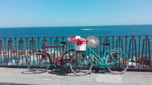シラクーサにあるLa Gorgone Ortigia Apartmentsの海辺の柵の横に2台駐輪