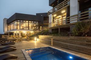 a building with a swimming pool in front of a building at Hotel Boutique Puramar in Curanipe