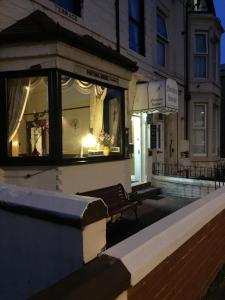 a bench in front of a building at night at Fortuna House Hotel in Blackpool