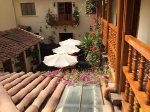 a courtyard with umbrellas and flowers on a building at Hotel Midori in Cusco