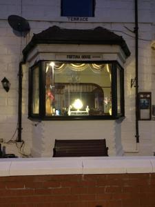 una ventana en un edificio con un banco. en Fortuna House Hotel, en Blackpool