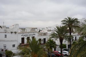 un bâtiment blanc avec des palmiers devant lui dans l'établissement Casa La Plaza, à Vejer de la Frontera