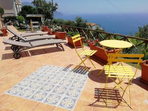 un patio con sillas y mesas en un balcón en Villa Donna Antonia - Amalfi Coast en Conca dei Marini