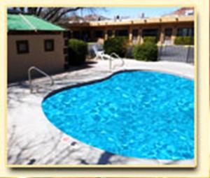 a large blue swimming pool in front of a building at Redrock Country Inn in Kanab