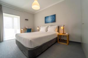 a hotel room with a large bed and a window at Agua d'Alma Hotel in Foz do Arelho