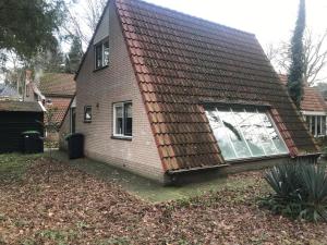 una casa con techo de tejas y ventana en Anna, en Nunspeet