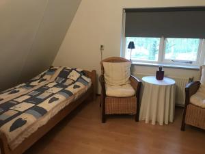 a bedroom with a bed and two chairs and a table at Anna in Nunspeet
