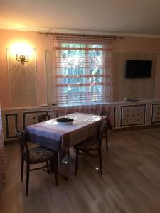 a dining room with a table and chairs and a television at Apple Tree Family Home (ECO) in Dzorakap