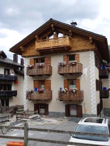 un edificio con balcones de madera y flores. en Casa Anita, en Livigno