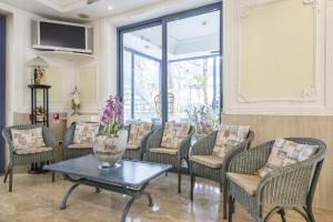 a group of chairs and a table with a vase of flowers at Royal Boutique Hotel NUOVA GESTIONE in Riccione