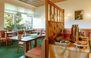 un comedor con mesas y sillas en un restaurante en Hotel Schleifmühle, en Holzminden