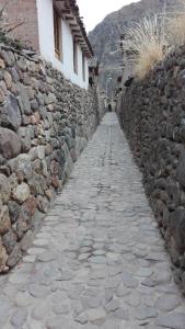 a stone path next to a stone wall at B&B Chayana Wasi in Ollantaytambo