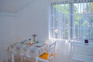 ein Esszimmer mit einem Tisch und einem großen Fenster in der Unterkunft Apartmani Mirko A1 in Molat