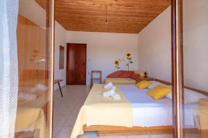 ein Schlafzimmer mit einem großen Bett mit gelben Kissen in der Unterkunft Apartmani Mirko A1 in Molat