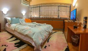 Dormitorio con cama, escritorio y TV en Hotel Square, en Skopje