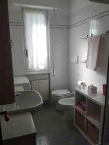 a white bathroom with a toilet and a sink at La Casa del Geco in Casarza Ligure