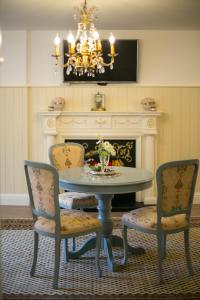 una sala da pranzo con tavolo, sedie e lampadario pendente di Romance Apartment a Kuldīga