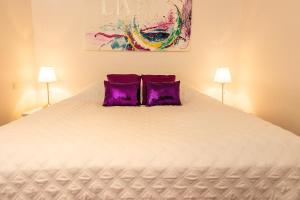 a bedroom with a large bed with two purple pillows at River Apartments in Selfoss