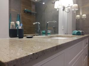 a bathroom counter with a sink and a mirror at Hel Amber Apart in Hel +17 photos