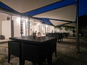 patio ze stołem i niebieskim baldachimem w obiekcie Hidden garden Deluxe w mieście Skiatos