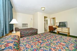 um quarto de hotel com uma cama e uma televisão de ecrã plano em Best Way Inn em Middlefield
