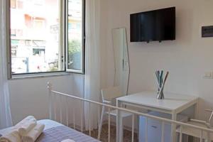 a bedroom with a bed and a desk and a television at Valente rooms in Agropoli