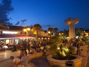 a group of people sitting in a plaza at night at Apartment Lola in Srima