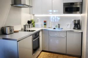 a kitchen with white cabinets and a refrigerator at Central Aleksanteri in Tampere