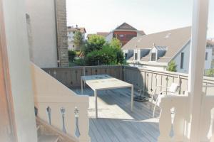 einen Balkon mit einem Tisch und einer Treppe in einem Haus in der Unterkunft Les Narcisses in Blonay