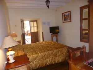 a bedroom with a bed and a couch and a television at Hotel Midori in Cusco