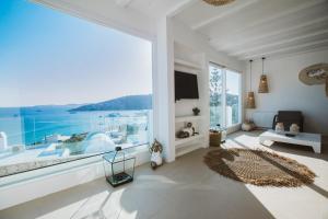 a large white living room with a large window at SeaCode Villas in Platis Yialos Mykonos