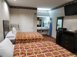 a hotel room with two beds and a bathroom at Scott Inn & Suites - Downtown Houston in Houston