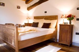 Villa di Tiranoにあるコントラーダ ベルトラメッリのベッドルーム1室(大型木製ベッド1台、ランプ2つ付)