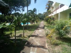 a walking path next to a building with palm trees at Ashari Hotel in Shanzu