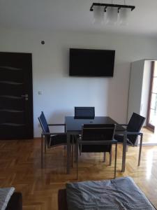 ein Esszimmer mit einem schwarzen Tisch und Stühlen in der Unterkunft Apartament Przy Skale u Anny in Sąpów