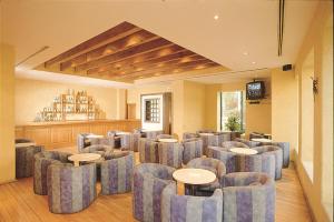 a waiting room with chairs and tables and a television at Hotel Sevilla in Mexico City