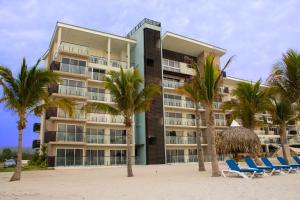 un hotel en la playa con palmeras y sillas en Playa Caracol Residences, en Chame