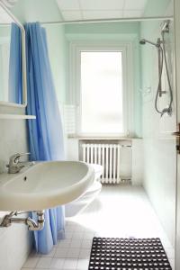 Jammin' Hostel & Bar Rimini في ريميني: حمام أبيض مع حوض ونافذة