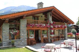a restaurant with tables and chairs in front of it at Hotel Lo Campagnar in Courmayeur