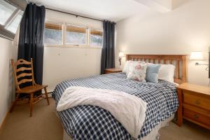 a bedroom with a bed and a chair and a window at Panorama Mountain Resort - Horsethief Lodge with Fairmont Creek in Panorama
