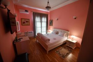 ロストフ・ナ・ドヌにあるPark Hotel Libhaberのピンクの壁のベッドルーム(ベッド1台、窓付)