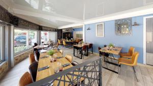 a dining room with tables and chairs in a restaurant at Hotel Saint Germain in Pézenas