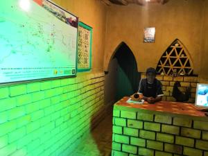 a man sitting at a counter in a room with a map at Maison Zouala in Zouala