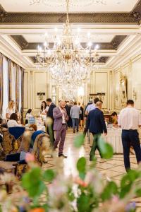 a crowd of people in a room with a chandelier at Hotel Bristol in Odesa