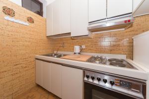 eine kleine Küche mit Spüle und Herd in der Unterkunft Apartman Zorica in Biograd na Moru