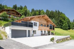 ein Haus mit einer Garage davor in der Unterkunft "Chalet Bergzeit" Ferienhaus mit Sauna & Wellness in Fügenberg