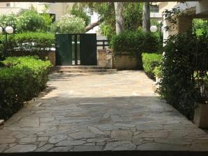a stone walkway with a gate in a garden at aris sweet home 2 in Athens